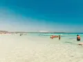 Splendida giornata al mare della Sardegna, con acque cristalline e gente che si gode il sole e il mare.