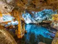 Stalattiti e stalagmiti illuminano le **grotte di Ispinigoli**, con un lago sotterraneo dalle acque cristalline e turchesi.