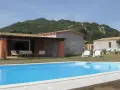 Una villa con piscina azzurra e montagne verdi sullo sfondo. Perfetta per una vacanza di relax, sa sippa.