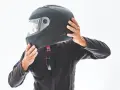 Persona indossa un casco integrale nero, pronto per un'avventura in moto.