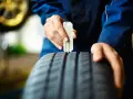 Meccanico controlla il battistrada moto con calibro. La sicurezza prima di tutto!