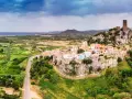 Borgo arroccato su una rupe con un castello medievale, affacciato su un paesaggio verdeggiante e il mare. La **posada dove si trova** è un gioiello incastonato nella roccia.
