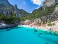 Spiaggia rosa di Budoni, incastonata tra scogliere imponenti e un mare cristallino.