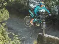 Un pilota esperto con una Honda Montesa compie un salto su un masso in un percorso fuoristrada.