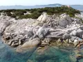 Scogliere rocciose e acque cristalline sulle spiagge a Villasimius. Turisti esplorano la costa selvaggia e si godono il sole.