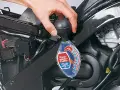 Controllo del liquido di raffreddamento a liquido moto con un densimetro. La mano tiene lo strumento per verificare la protezione antigelo.