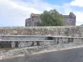 Fontana in pietra con scorci di un antico edificio religioso, un'oasi di pace ad **Allai, Sardegna**.