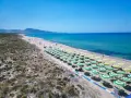 Spiaggia di Badesi: file di ombrelloni verdi e gialli, mare azzurro e dune sabbiose. Cosa vedere in questo paradiso.
