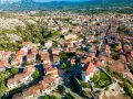 Vista aerea del centro storico di Arzachena, con le sue case dai tetti rossi e la chiesa in primo piano.