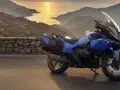 Moto blu parcheggiata su un promontorio con vista sul mare al tramonto. La corretta pressione gomme moto è fondamentale per un viaggio sicuro.