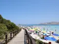 La Pelosa, Stintino: cosa vedere in questo paradiso. Spiaggia affollata, mare turchese, torre aragonese e passerella in legno.