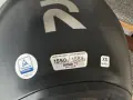 Casco nero con logo R argentato. Etichette indicano peso, modello RPHA 71, certificazione e taglia XS. Sul casco possono essere applicati adesivi.