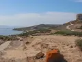 Torre aragonese su un colle roccioso, con rovine antiche e mare sullo sfondo, un paesaggio suggestivo di Tharros, Sardegna.