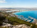 Vista panoramica del **percorso** verso la **Sella del Diavolo**, con il porto turistico, la spiaggia e la città sullo sfondo.