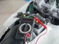 Multimetro collegato alla batteria della moto per verificarne lo stato prima di staccare la batteria moto inverno.