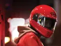 Un motociclista indossa un casco integrale rosso brillante, pronto per la strada.