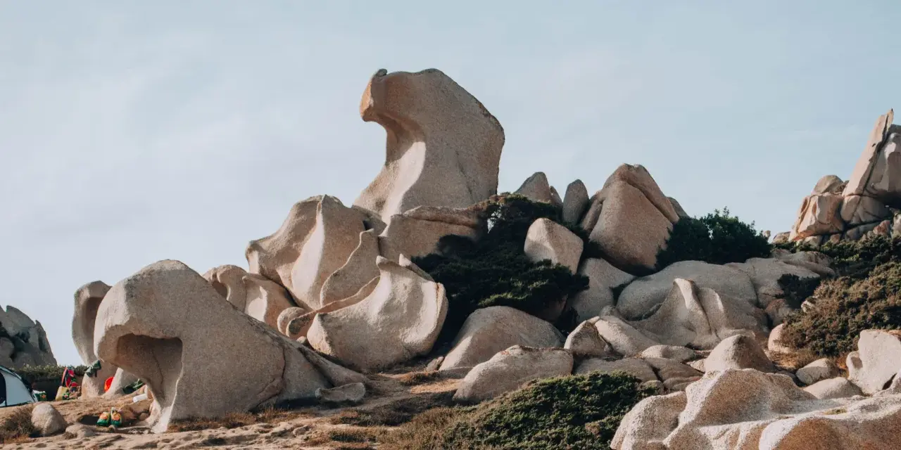 Formazioni rocciose scolpite dal vento nella Valle della Luna, Santa Teresa di Gallura. Un paesaggio lunare con rocce levigate e macchia mediterranea.