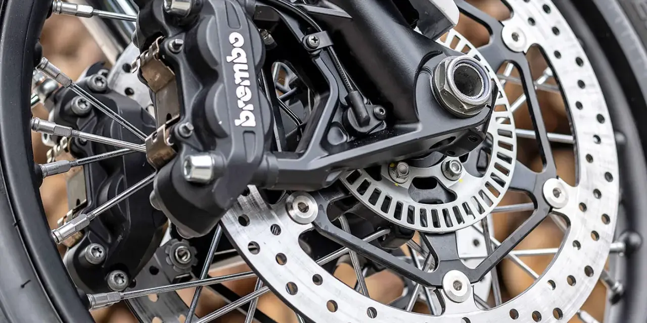 Primo piano della pinza freno Brembo e del disco forato, dettagli per la sostituzione pastiglie freni moto.