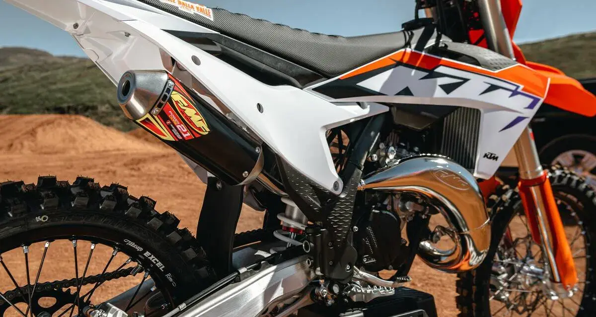 Scarico FMF su KTM arancione e bianca. La moto da cross, con il suo motore 2t, è pronta per la pista.