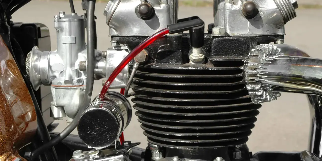 Motore bicilindrico **2 tempi moto** con carburatore cromato e tubo benzina rosso.