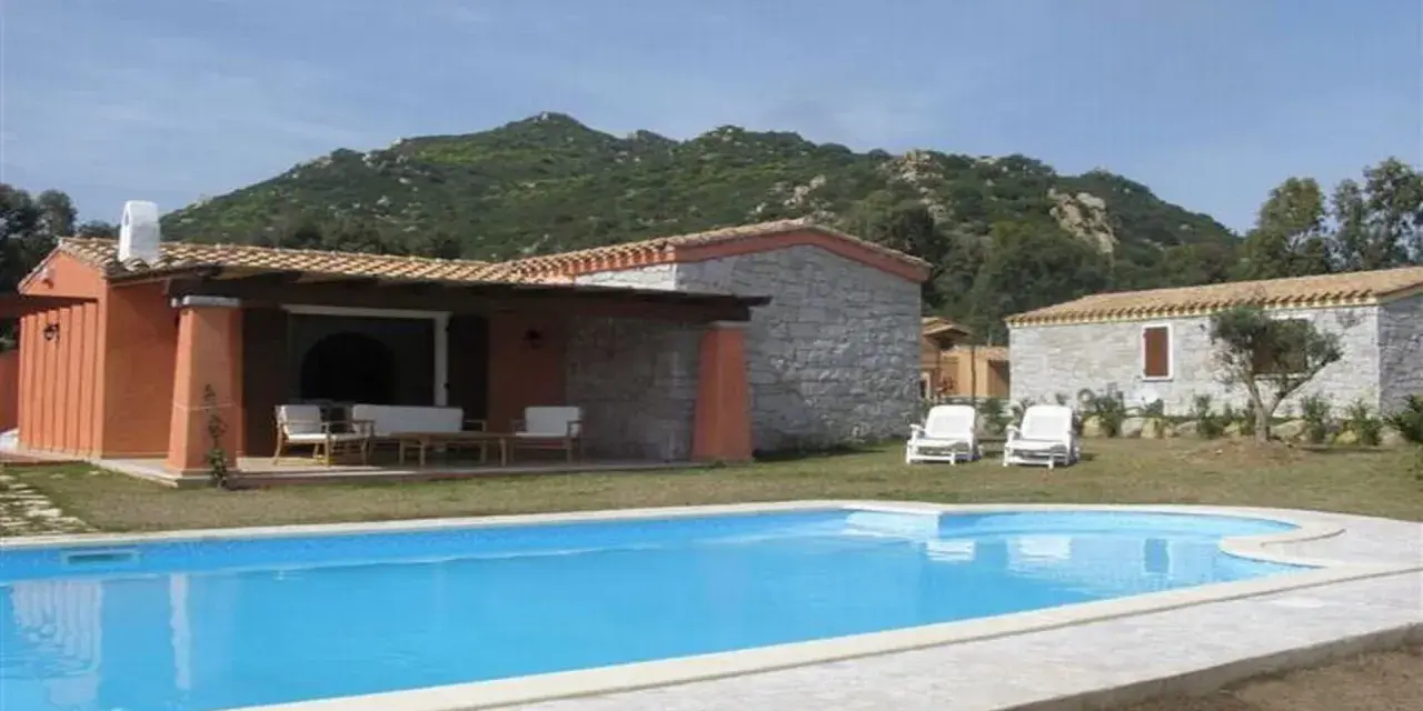 Una villa con piscina azzurra e montagne verdi sullo sfondo. Perfetta per una vacanza di relax, sa sippa.