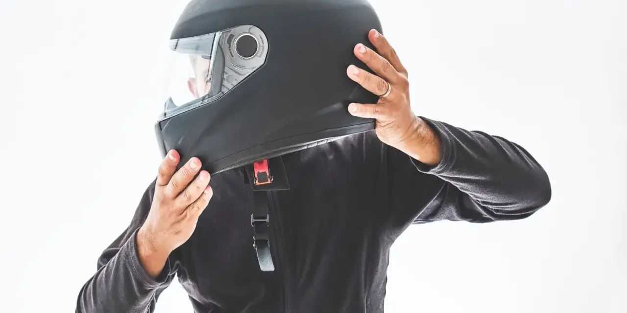 Persona indossa un casco integrale nero, pronto per un'avventura in moto.
