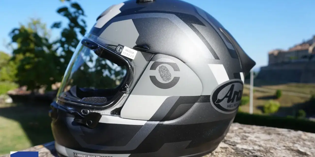 Casco moto Arai con grafica camouflage, visiera trasparente e adesivo di certificazione E4. Sicurezza garantita per ogni avventura.