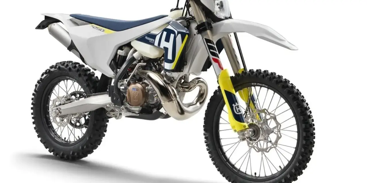 Moto da cross Husqvarna bianca e blu, con scarico a vista. Un esempio di motore 2 tempi, diverso dal 4 tempi.