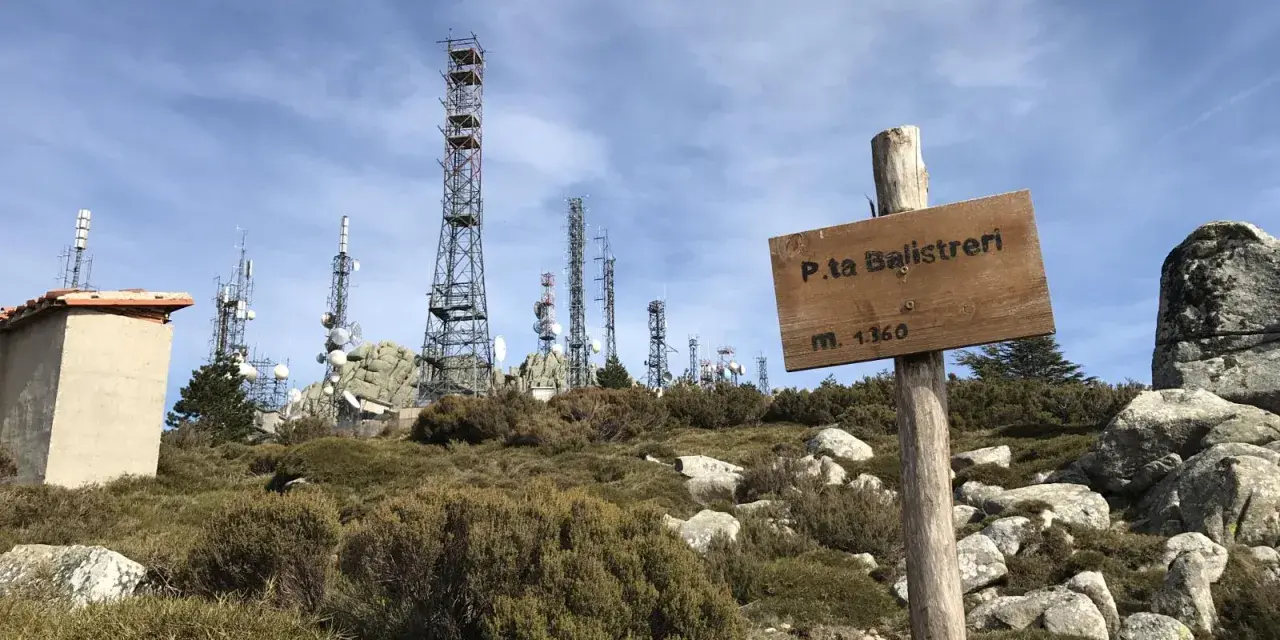 Segnale in legno a Punta Balistreri, m. 1360, con torri di telecomunicazioni sullo sfondo.