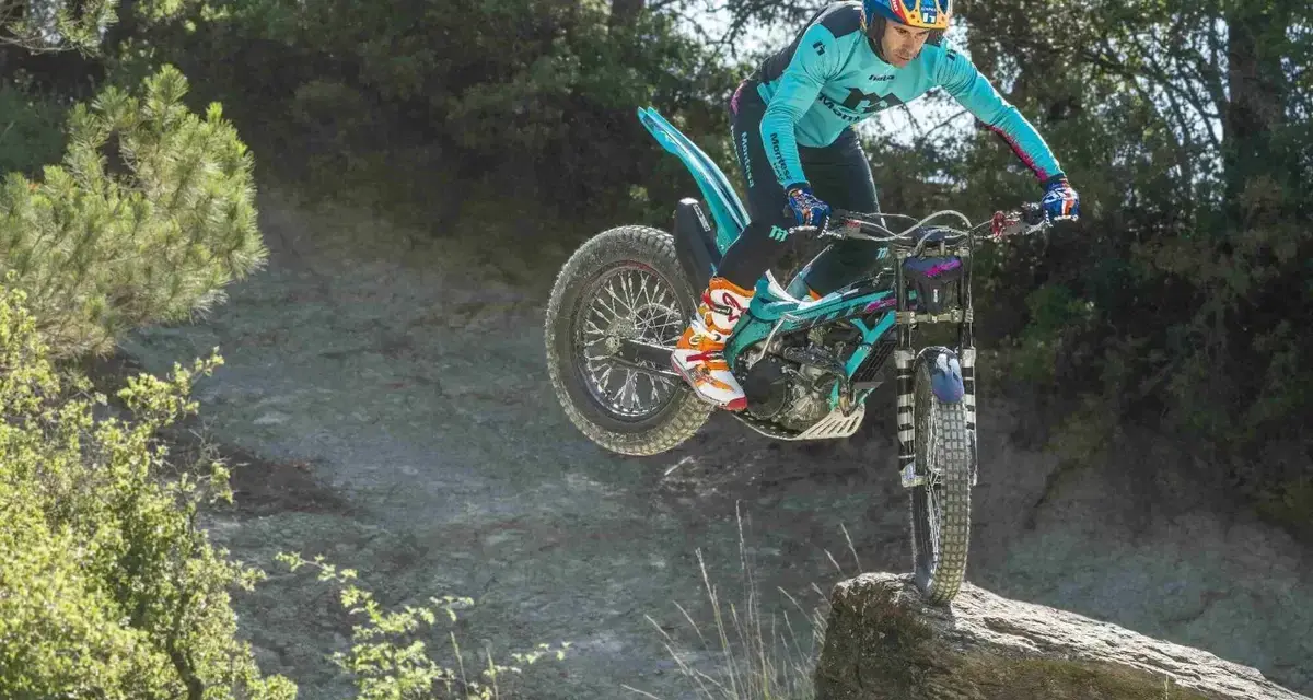 Un pilota esperto con una Honda Montesa compie un salto su un masso in un percorso fuoristrada.