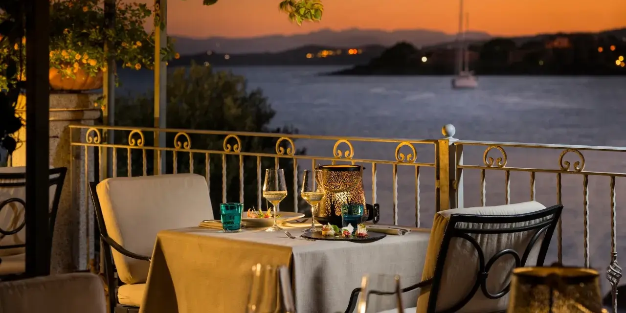 Tavola apparecchiata con vista sul golfo al tramonto. Atmosfera romantica in uno dei ristoranti di Golfo Aranci.