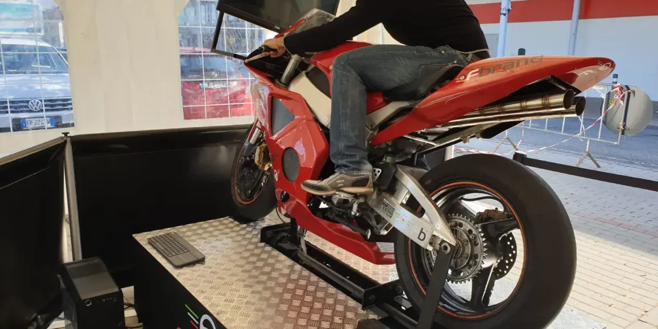 Uomo su una moto rossa da corsa, seduto su un simulatore di guida. Un'esperienza di guida virtuale con un sag moto.