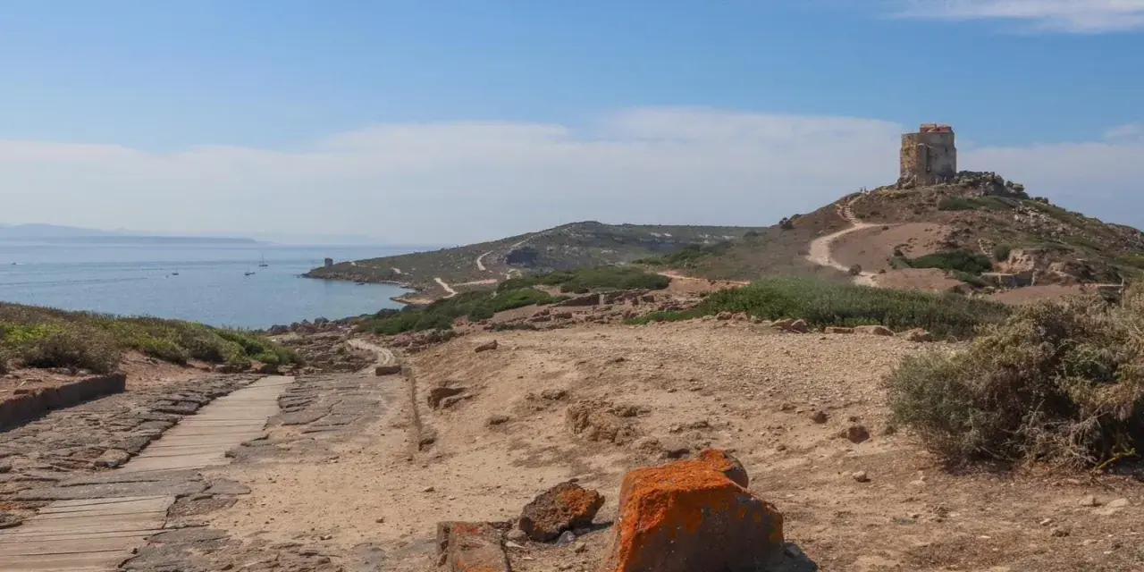 Torre aragonese su un colle roccioso, con rovine antiche e mare sullo sfondo, un paesaggio suggestivo di Tharros, Sardegna.