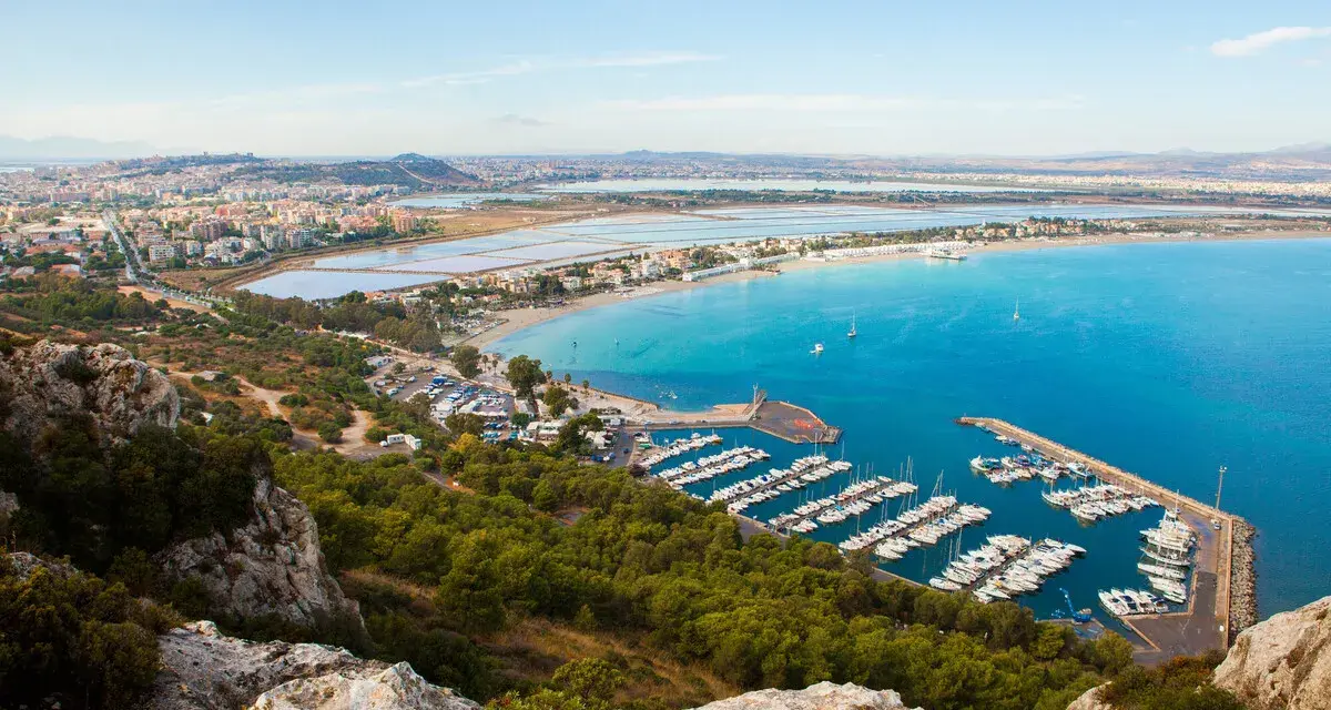 Vista panoramica del **percorso** verso la **Sella del Diavolo**, con il porto turistico, la spiaggia e la città sullo sfondo.