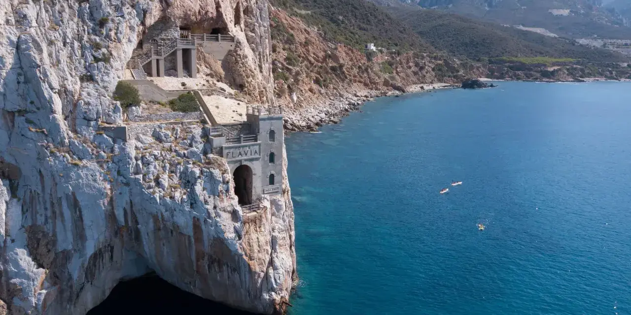 Porto Flavia, un'antica miniera a picco sul mare. Come arrivare: in auto o con tour in barca per ammirare la costa.