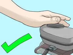 Mano che copre il serbatoio della pompa frizione, con segno di spunta verde. Procedura per come spurgare pompa frizione completata con successo.