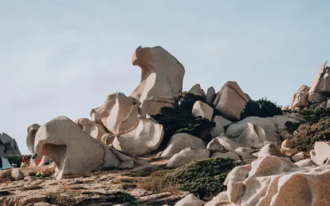 Formazioni rocciose scolpite dal vento nella Valle della Luna, Santa Teresa di Gallura. Un paesaggio lunare con rocce levigate e macchia mediterranea.
