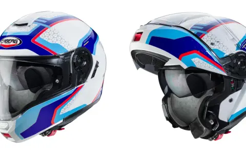 Due caschi da moto bianchi con grafiche blu, rosse e azzurre. Uno è un casco integrale, l'altro è un modulare aperto.