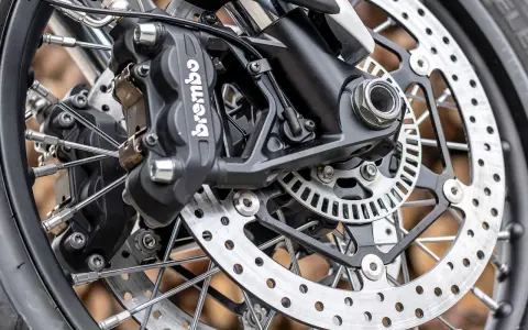 Primo piano della pinza freno Brembo e del disco forato, dettagli per la sostituzione pastiglie freni moto.