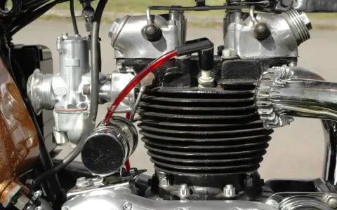 Motore bicilindrico **2 tempi moto** con carburatore cromato e tubo benzina rosso.