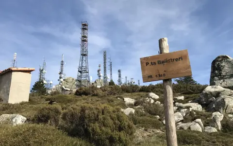 Segnale in legno a Punta Balistreri, m. 1360, con torri di telecomunicazioni sullo sfondo.