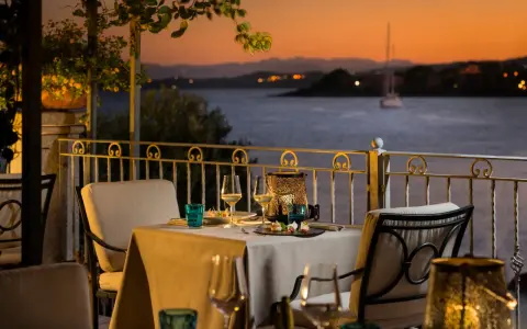 Tavola apparecchiata con vista sul golfo al tramonto. Atmosfera romantica in uno dei ristoranti di Golfo Aranci.