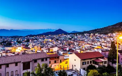 Vista serale di Cala Gonone, con luci accese tra le case. Perfetto per scoprire cosa fare la sera.