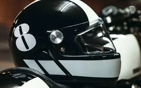 Casco nero con numero 8 bianco e strisce. Per sapere come non far appannare la visiera del casco, guarda questo dettaglio.