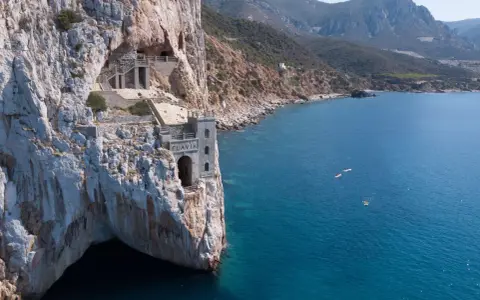 Porto Flavia, un'antica miniera a picco sul mare. Come arrivare: in auto o con tour in barca per ammirare la costa.