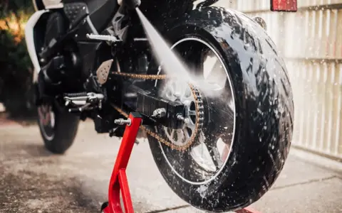 Lavaggio catena moto con idropulitrice, pronta per il rimessaggio.