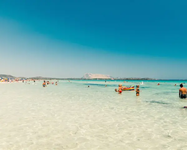 Splendida giornata al mare della Sardegna, con acque cristalline e gente che si gode il sole e il mare.