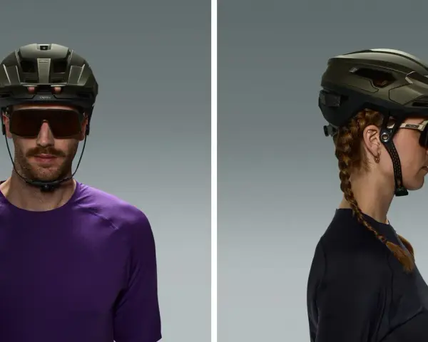 Uomo e donna indossano diversi tipi di casco da ciclismo, uno frontale e uno laterale, con occhiali sportivi.