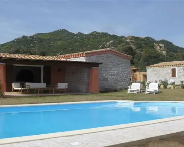 Una villa con piscina azzurra e montagne verdi sullo sfondo. Perfetta per una vacanza di relax, sa sippa.
