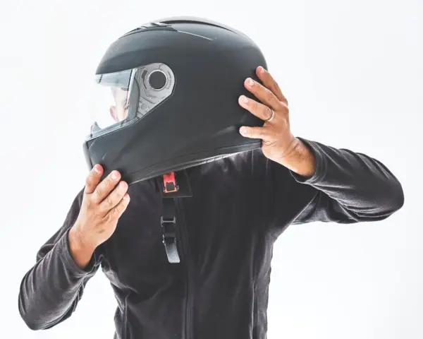 Persona indossa un casco integrale nero, pronto per un'avventura in moto.